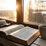 Imagem de manhã tranquila com uma bíblia aberta, café e luz suave entrando pela janela, simbolizando fé e renovação espiritual para a segunda-feira.