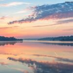 Nascer do sol sereno sobre um lago calmo com cores pastéis suaves