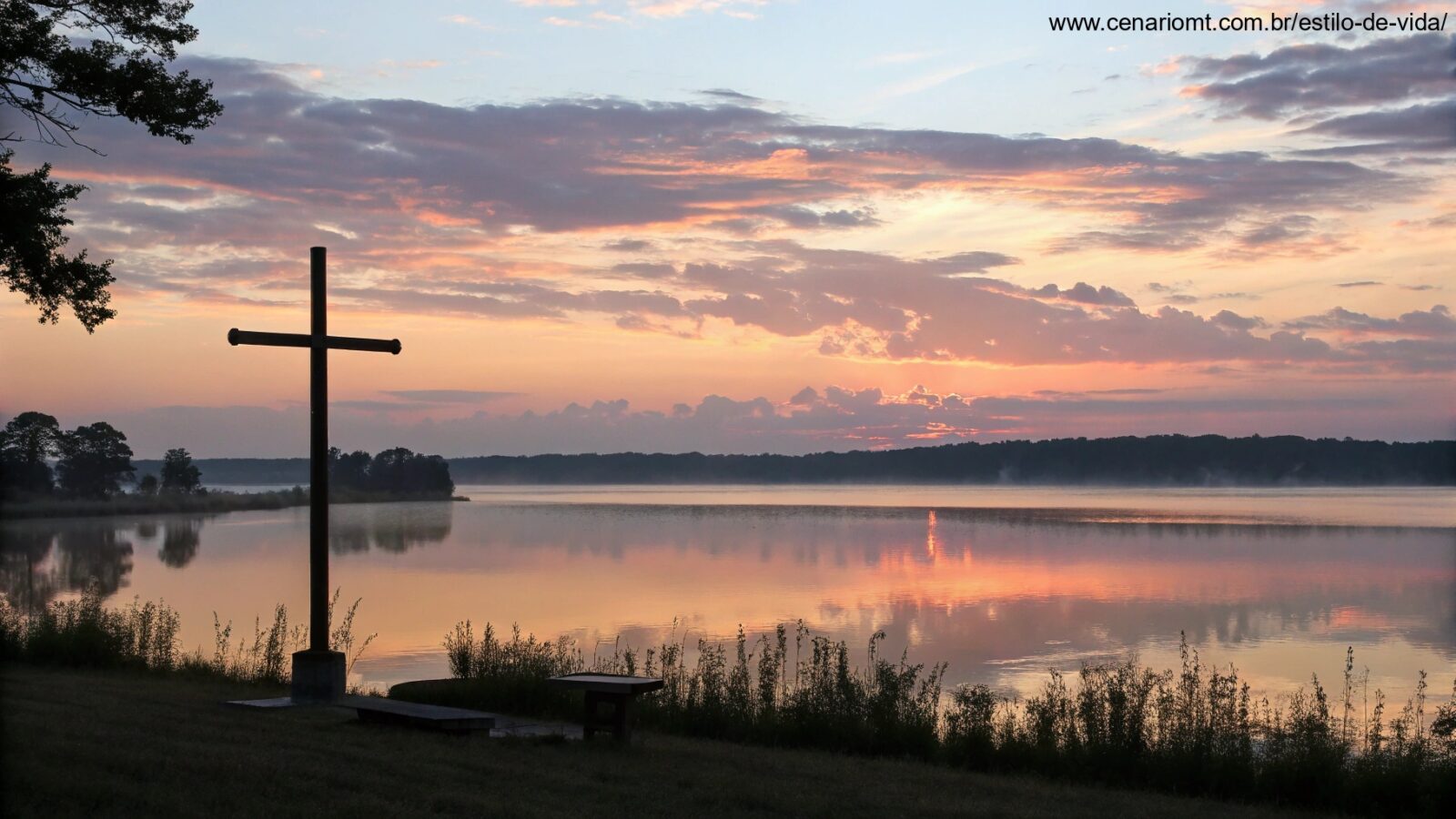 Nascer do sol sereno sobre um lago calmo com uma silhueta de uma cruz em primeiro plano, simbolizando uma manhã tranquila com Deus.