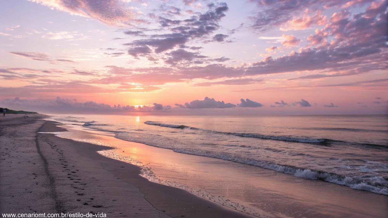 Imagem de um amanhecer tranquilo com cores suaves e ondas calmas na praia