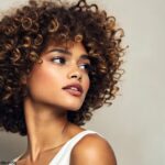 Mulher estilosa com cabelo cacheado, usando um corte bob, exibindo volume natural e definição.