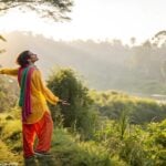Pessoa vestindo roupas coloridas em um ambiente natural, irradiando uma sensação de bem-estar.
