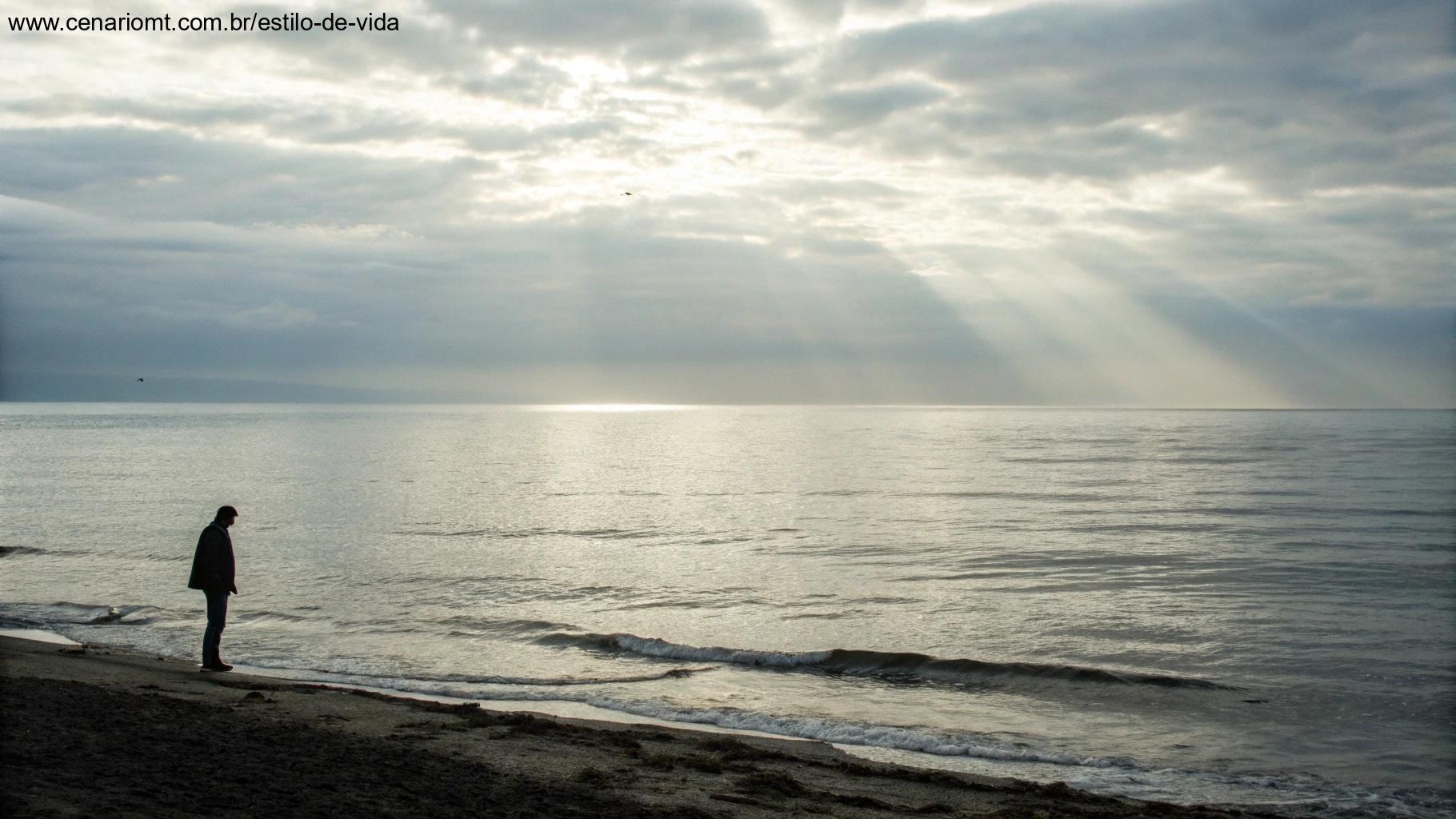 Imagem de uma vista tranquila do oceano com uma pessoa olhando para o horizonte.