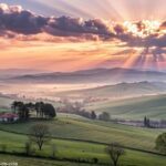 Amanhecer sereno no campo com raios de sol para uma sexta-feira abençoada.