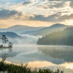Paisagem serena de manhã com luz suave, colinas enevoadas e um lago tranquilo refletindo o céu