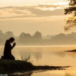 Paisagem tranquila ao amanhecer, com luz dourada suave refletindo nas águas calmas, e uma silhueta de uma pessoa orando, simbolizando fé e união para uma manhã de sexta-feira em um grupo religioso.