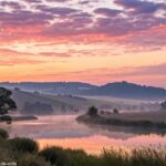Uma paisagem tranquila ao amanhecer, com cores suaves e luz suave, simbolizando um novo começo e inspiração para um novo dia.