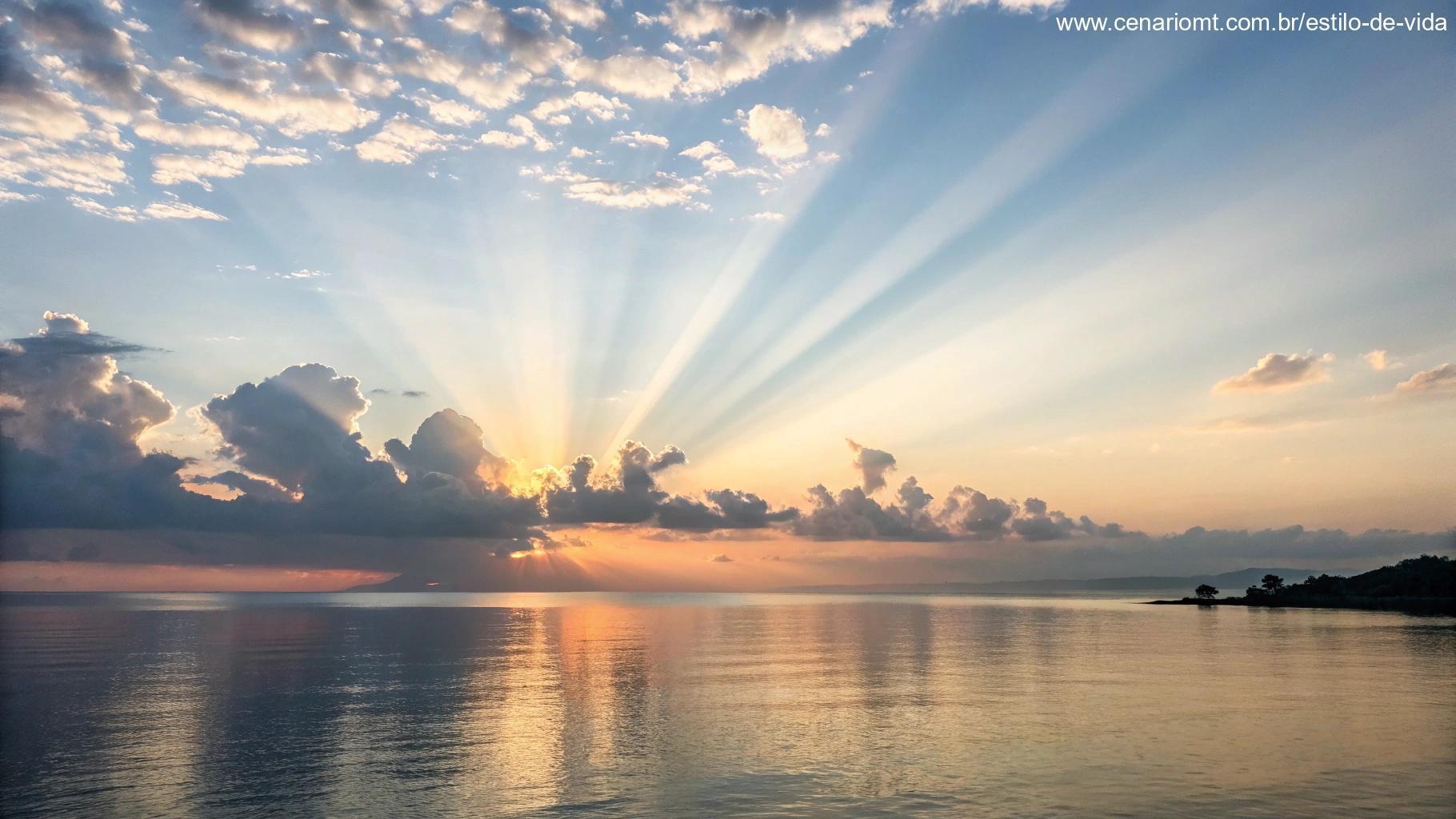 Amanhecer pacífico com raios suaves de luz sobre um horizonte calmo, simbolizando esperança e antecipação.