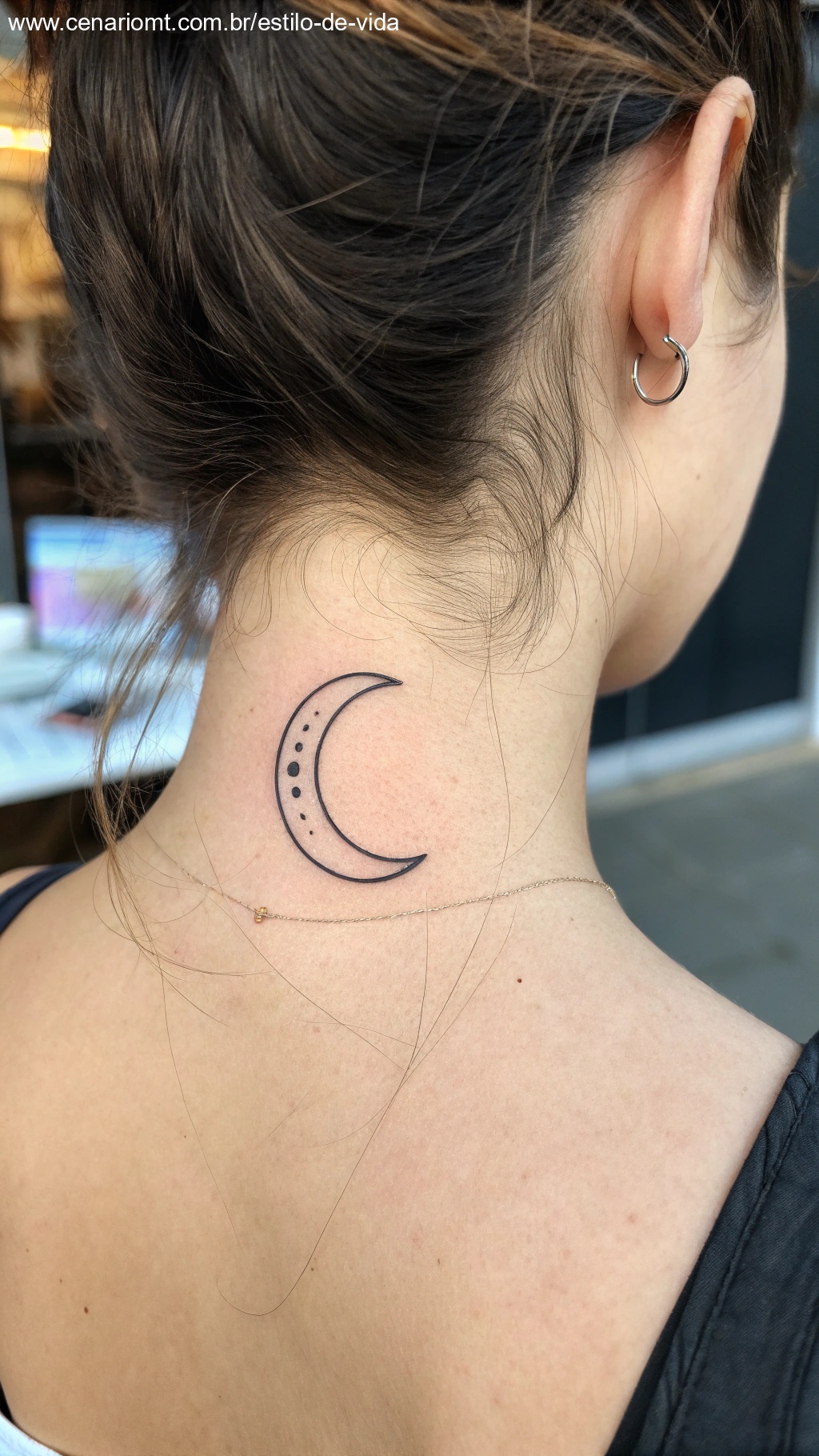 Tatuagem minimalista elegante de uma lua crescente no pescoço.
