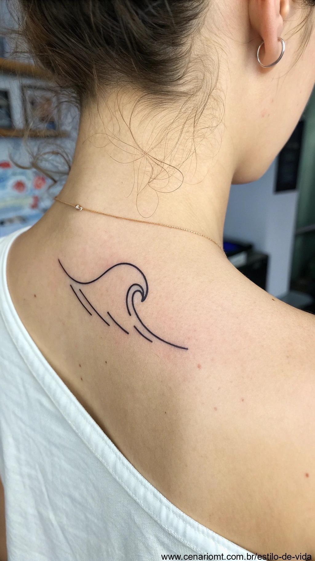 Tatuagem minimalista abstrata de uma onda na clavícula.