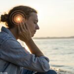 Pessoa sentada em um ambiente calmo, com a mão tocando suavemente a orelha direita, com uma aura suave e luminosa ao redor, simbolizando o significado espiritual.