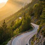 Ciclista subindo estrada íngreme ao amanhecer