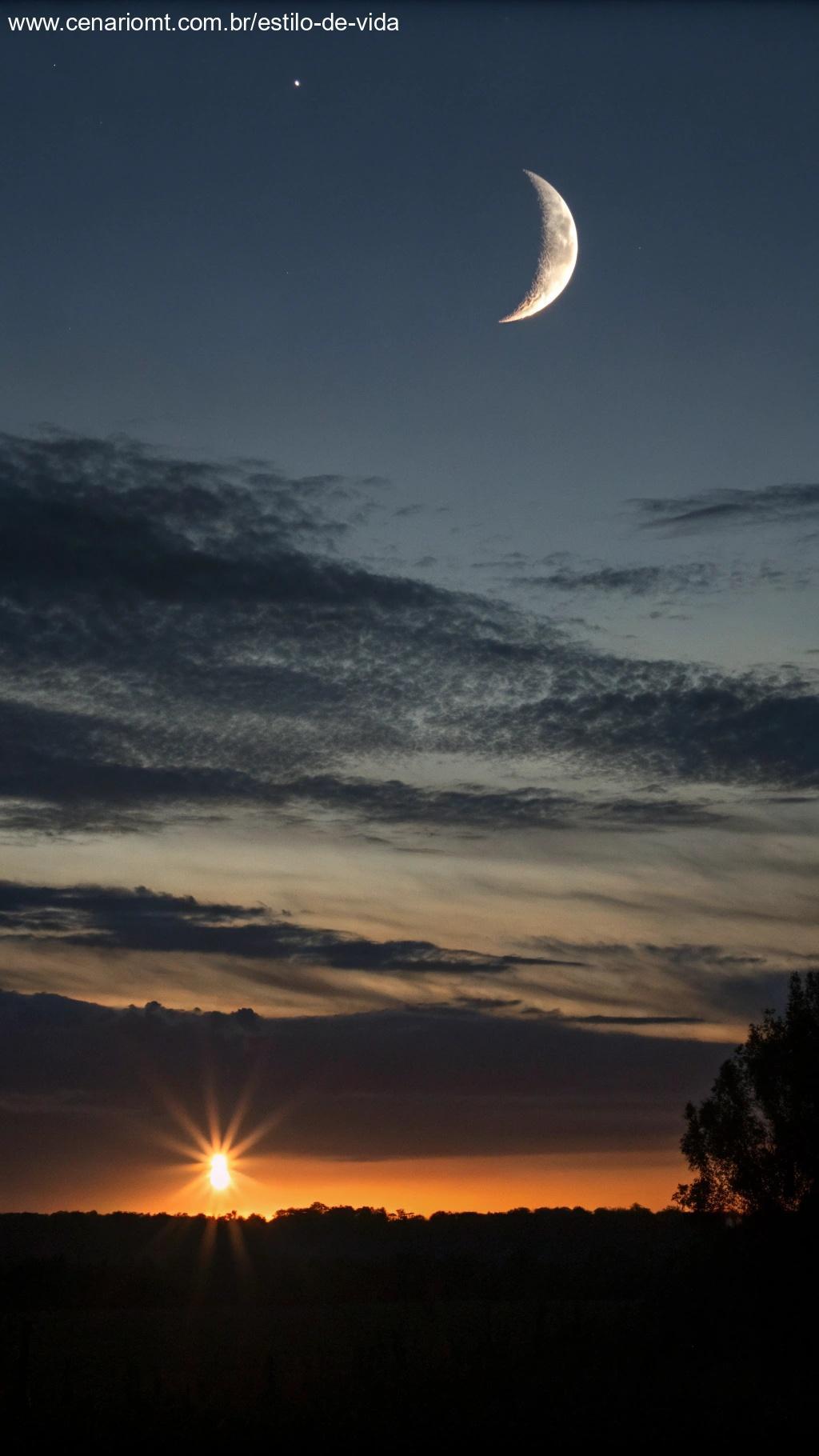 Céu escuro com lua nova e luz no horizonte, representando o início do ciclo lunar.