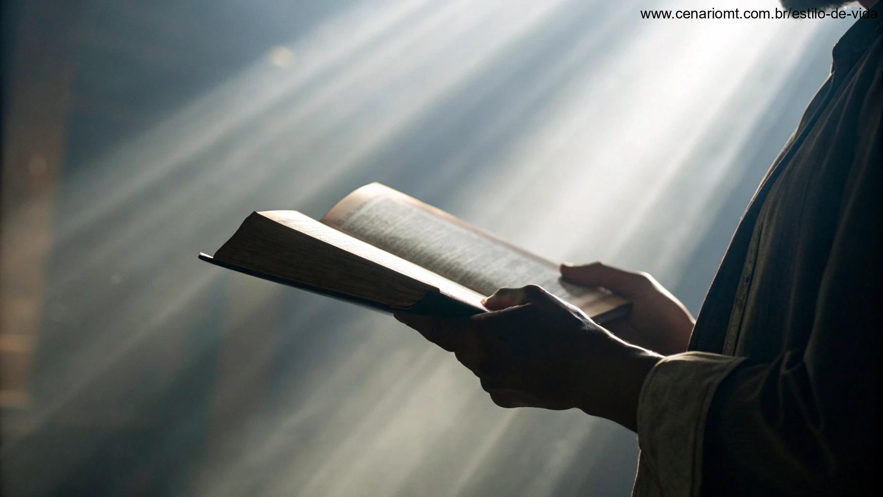 Imagem de uma mão segurando uma Bíblia com raios de luz iluminando-a, representando a aplicação da palavra de Deus no dia a dia.