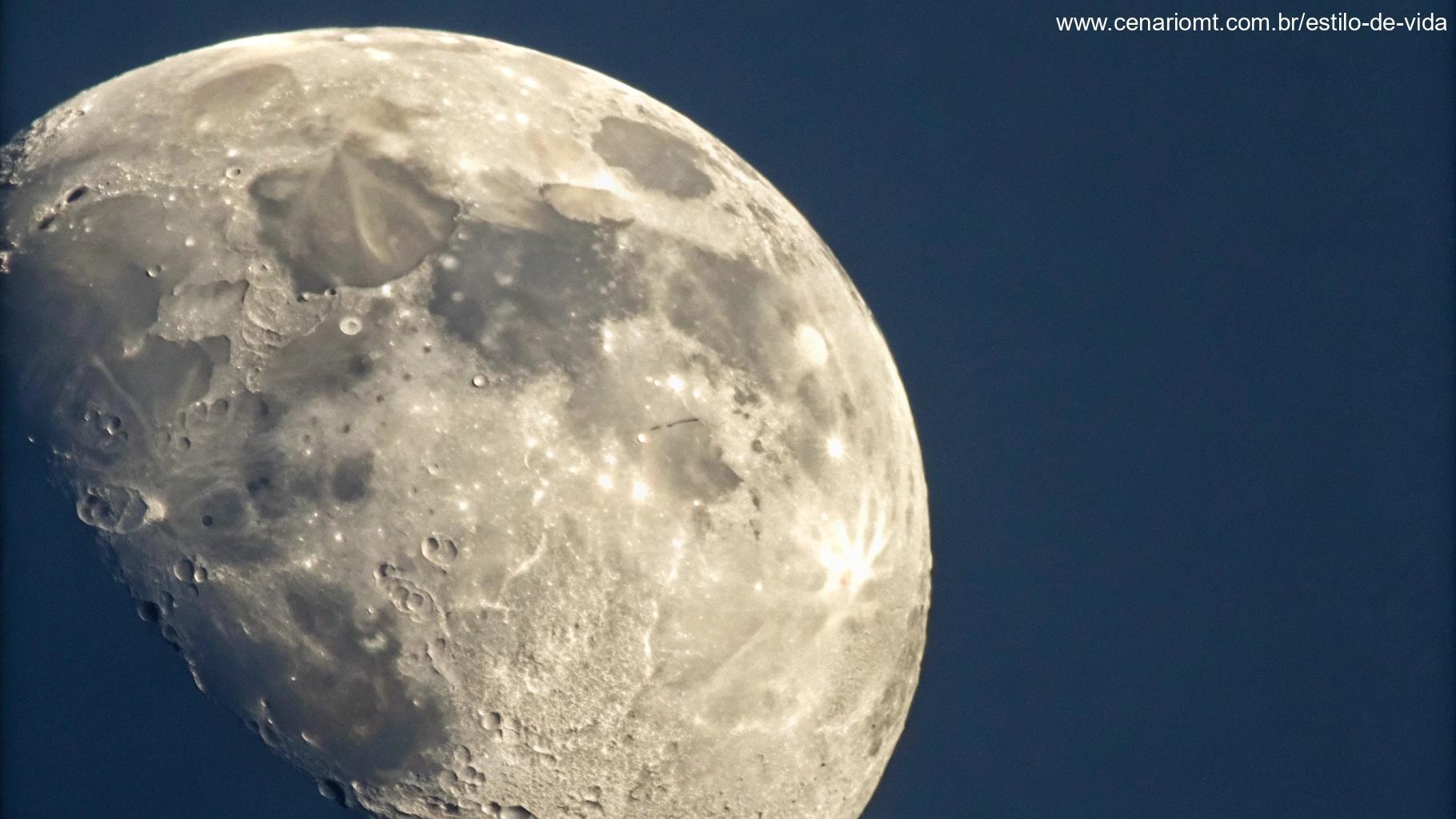 Vista aproximada da Lua Gibosa Crescente, com detalhes intrincados de sua superfície, crateras e o brilho suave ao seu redor, em um vasto céu escuro.