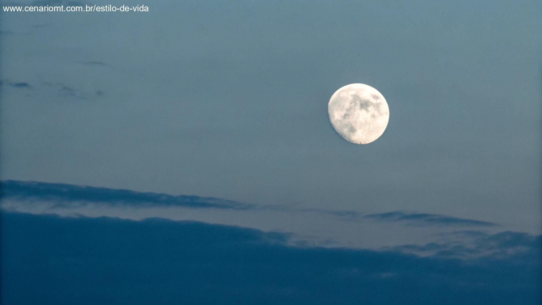 Ilustração minimalista do tamanho aparente da lua no céu, representada como um pequeno círculo branco em um céu crepuscular gradiente