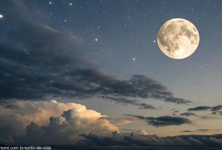 Céu noturno sereno com uma lua gibosa minguante, parcialmente iluminada, cercada por estrelas fracas e nuvens suaves