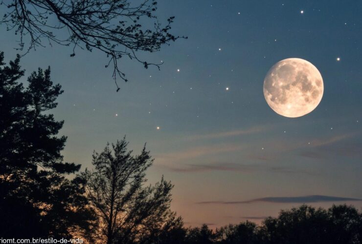 Céu sereno e claro com a lua gibosa minguante ao fundo, brilhando suavemente cercada por estrelas, e um leve gradiente de azul escuro para preto no céu.