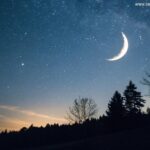 Céu noturno sereno com uma lua crescente brilhante, rodeada por estrelas fracas