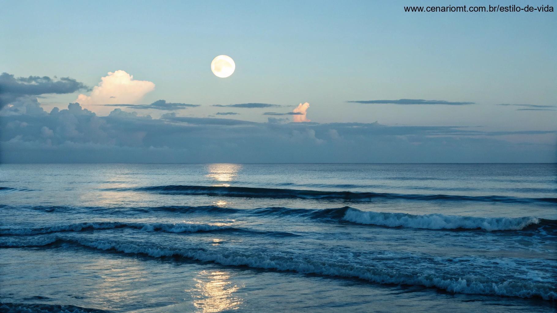 Cena oceânica tranquila com ondas suaves sob a luz de uma lua gibosa minguante, refletindo na superfície da água