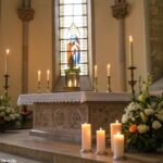 Altar de igreja com velas acesas e flores, com luz suave entrando pelas janelas de vitral.