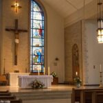 Igreja tranquila com altar simples e vitrais coloridos, transmitindo um ambiente de reflexão.