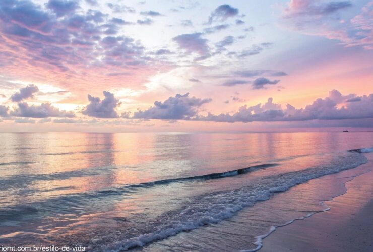 Amanhecer pacífico sobre um oceano calmo, com cores suaves no céu, simbolizando esperança e serenidade para uma manhã abençoada de sexta-feira.