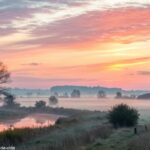 Amanhecer tranquilo e acolhedor com cores suaves, refletindo uma atmosfera calma e positiva ideal para uma saudação de domingo.