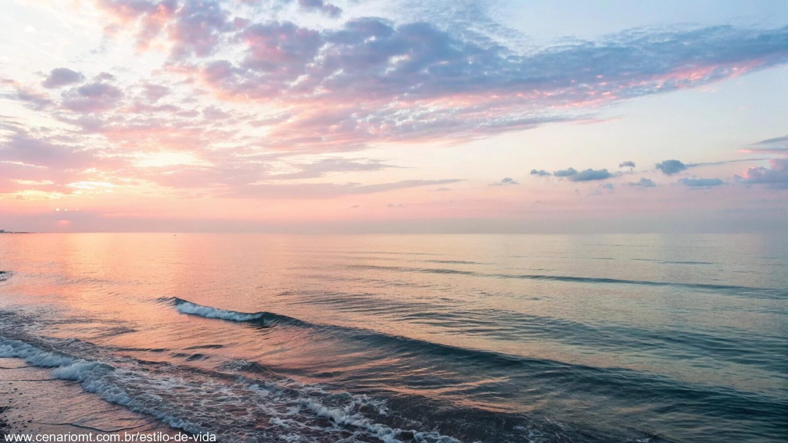 Uma imagem serena de um amanhecer tranquilo sobre o mar, com cores suaves no céu e ondas calmas refletindo a luz do sol.