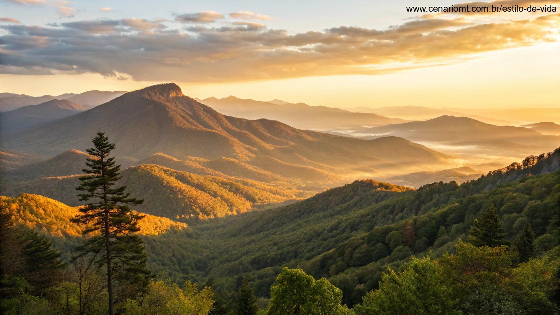Vista de montanha ao amanhecer com os primeiros raios de luz sobre os picos, iluminando a paisagem com um brilho dourado.