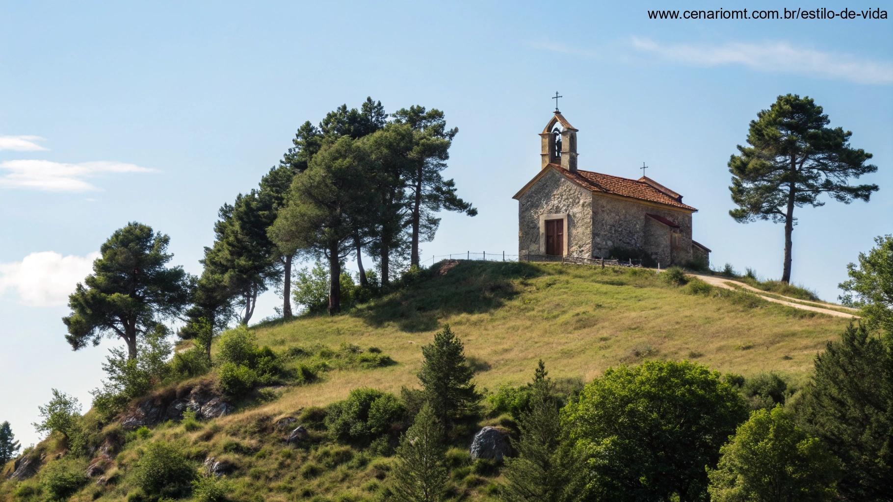 Uma igreja simples e tranquila no topo de uma colina, cercada pela natureza, sob um céu azul claro.