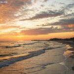 Imagem de um pôr do sol tranquilo em uma praia calma