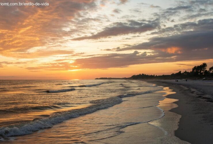 Imagem de um pôr do sol tranquilo em uma praia calma