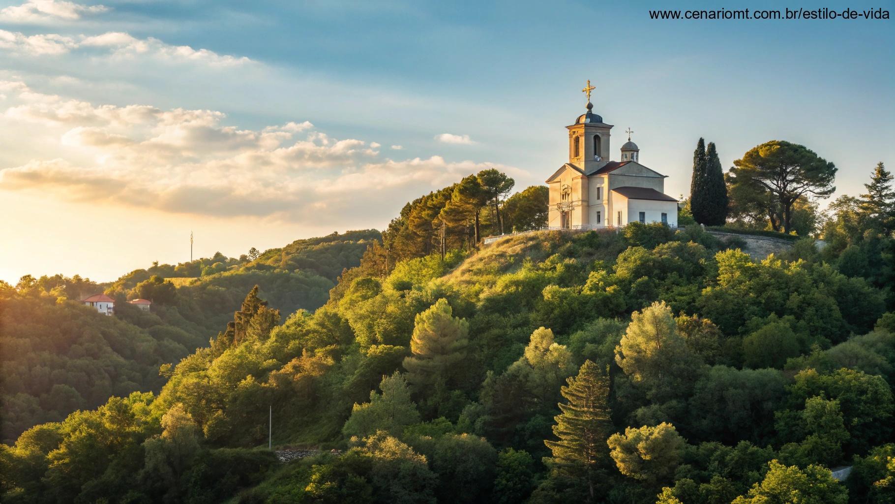 Vista serena de uma igreja em uma colina cercada por árvores verdes sob um céu azul brilhante.