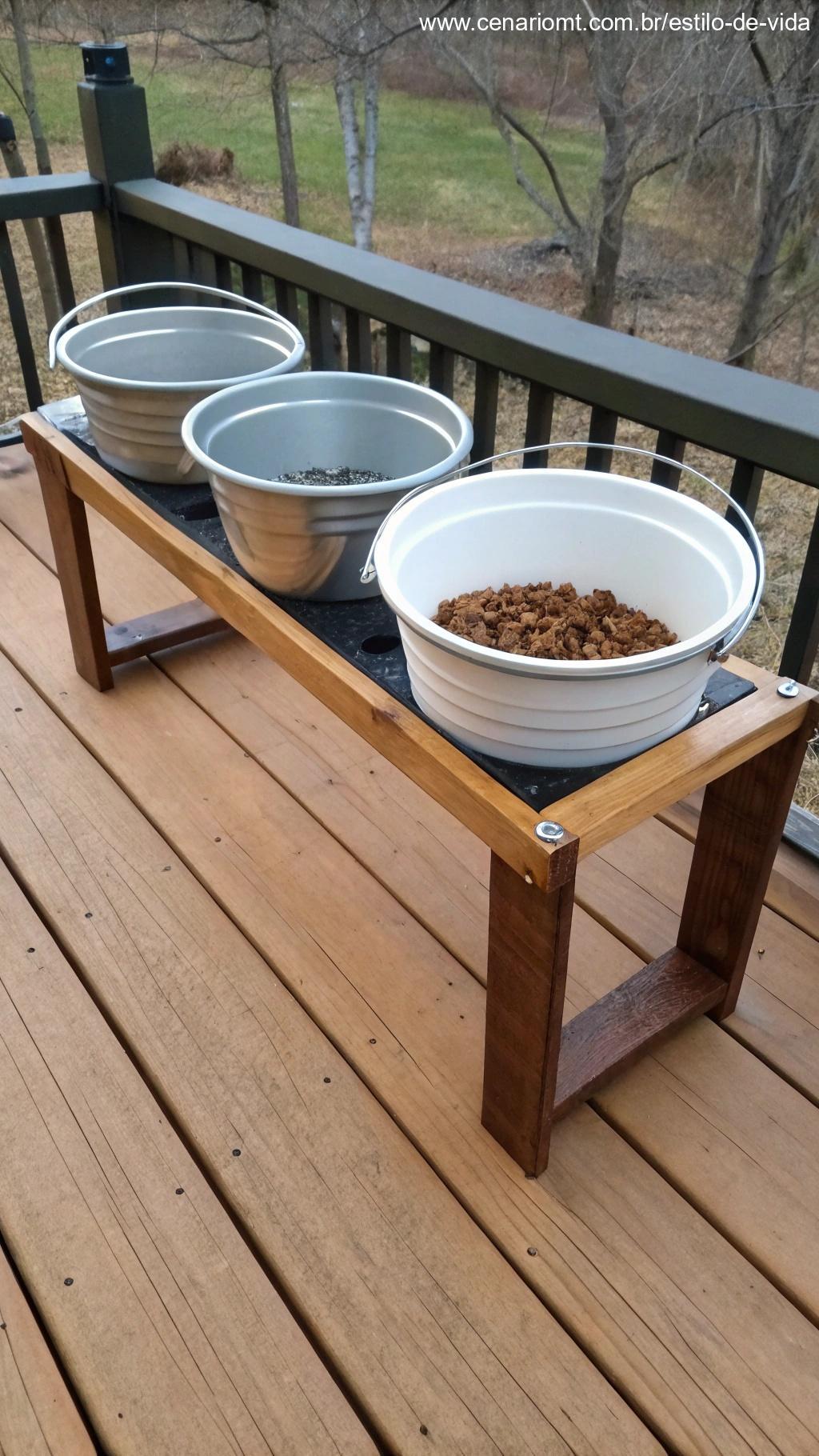 Comedouro elevado para pets feito com baldes em deck de madeira