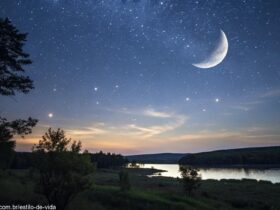 Cena tranquila mostrando a lua minguante em um céu estrelado com uma paisagem calma abaixo, representando a energia tranquila desta fase lunar.