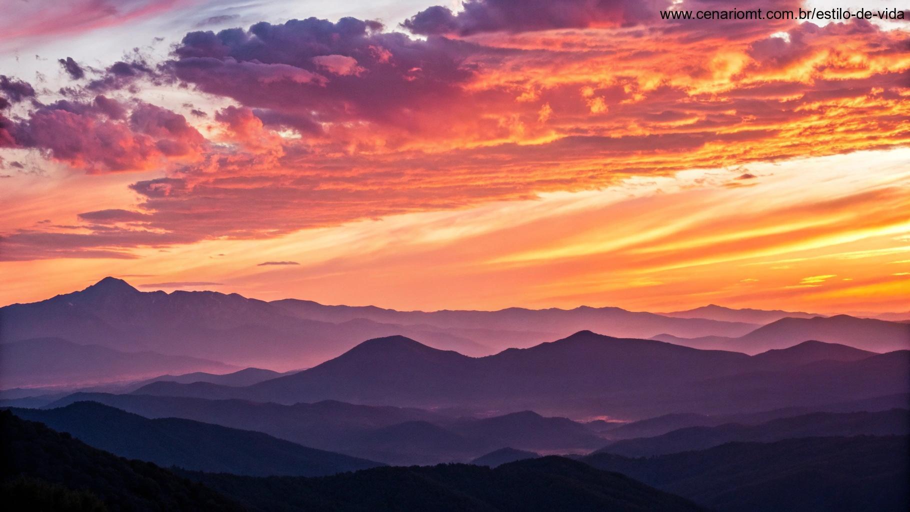 Um amanhecer inspirador sobre uma cadeia de montanhas, com cores vibrantes no céu e a primeira luz do dia iluminando a paisagem, representando novos começos e pensamentos positivos.
