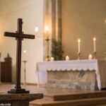 Cena tranquila de uma igreja com iluminação suave, uma cruz no altar e velas acesas ao fundo, evocando um senso de reflexão e oração.