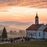 Imagem de um nascer do sol tranquilo sobre uma igreja no campo com pessoas orando