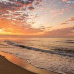 Imagem motivacional para começar a semana com otimismo, mostrando o amanhecer, uma praia tranquila e ondas suaves.