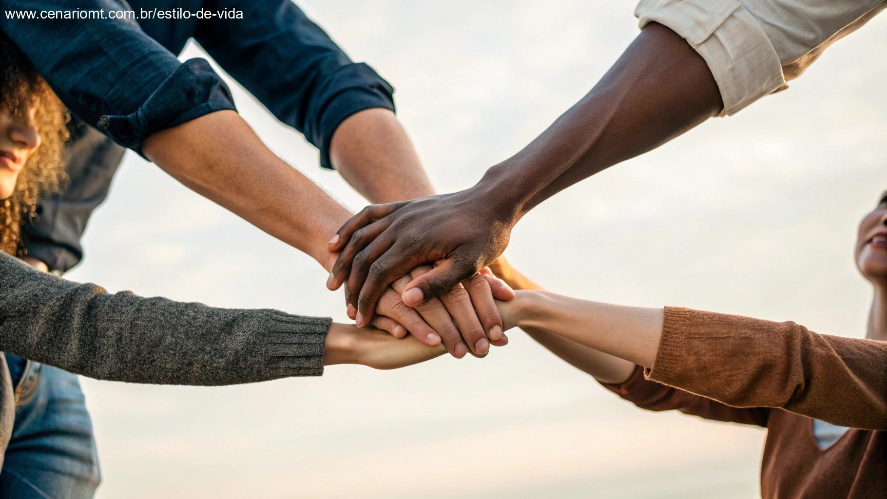 Grupo diversificado de mãos unidas em círculo contra um fundo desfocado suave