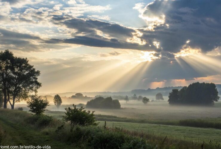 Imagem de uma paisagem serena, com raios de luz irradiando através das nuvens, simbolizando reflexão e crescimento espiritual.