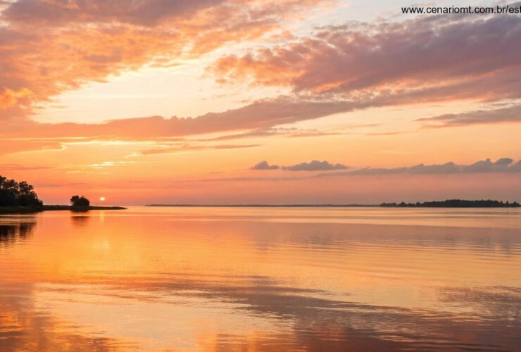 Nascer do sol sereno sobre águas calmas com luz dourada refletindo na superfície