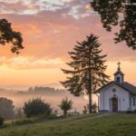 Cena religiosa inspiradora ao nascer do sol, com luz dourada suave e uma capela simples