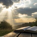 Bíblia aberta sob luz do sol em um cenário natural tranquilo, simbolizando inspiração divina