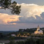 Paisagem serena com uma igreja ao fundo, simbolizando reflexão espiritual e oração.