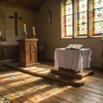 Interior de uma capela iluminada pela manhã com altar simples e atmosfera de reflexão