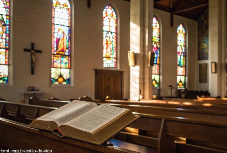 Igreja tranquila com vitrais iluminados e Bíblia aberta no altar