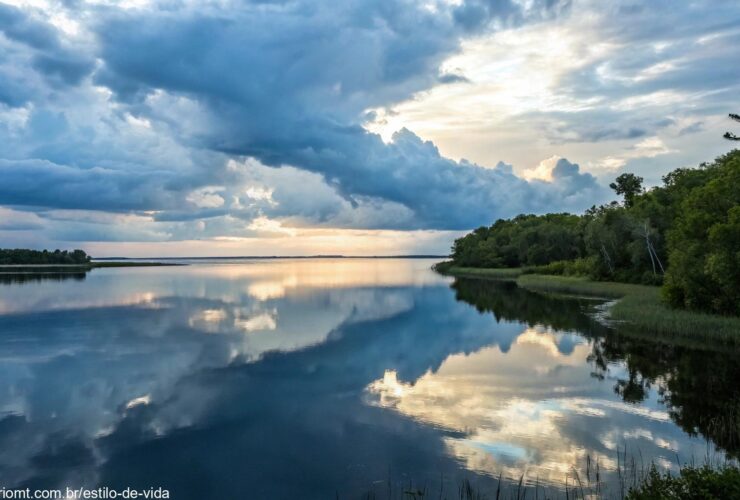 Paisagem serena com águas calmas refletindo o céu, simbolizando paz e reflexão, com iluminação suave e ambiente tranquilo, transmitindo uma sensação de tranquilidade espiritual.