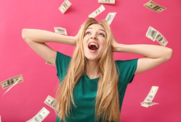 Mulher jovem feliz e notas de dólar caindo na cor de fundo - Fotos do Canva